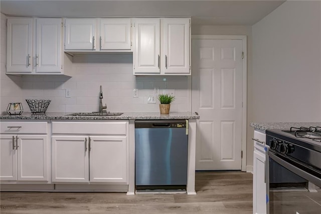 kitchen featuring light stone counters, white cabinetry, dishwasher, and a sink