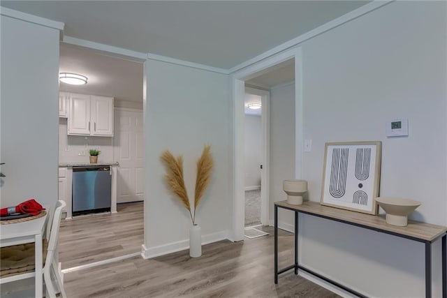 interior space featuring light wood-style floors, light countertops, white cabinets, and dishwasher