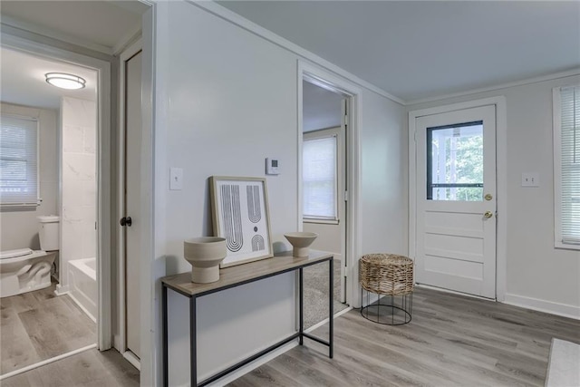 doorway featuring light wood-style flooring and baseboards