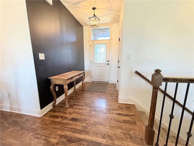 entryway featuring stairway, baseboards, wood finished floors, and vaulted ceiling