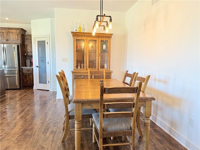 dining space with baseboards and dark wood-style floors