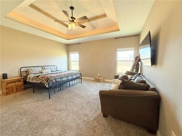 bedroom with light carpet, ceiling fan, a raised ceiling, and baseboards