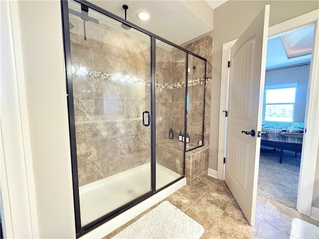 ensuite bathroom with connected bathroom, baseboards, and a stall shower