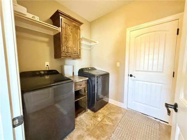 laundry room featuring washer and dryer, baseboards, and cabinet space