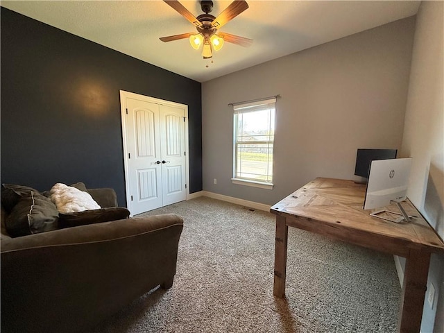 carpeted office with baseboards and a ceiling fan