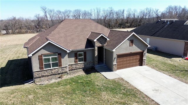 view of front of home featuring a front yard, driveway, stucco siding, a garage, and stone siding