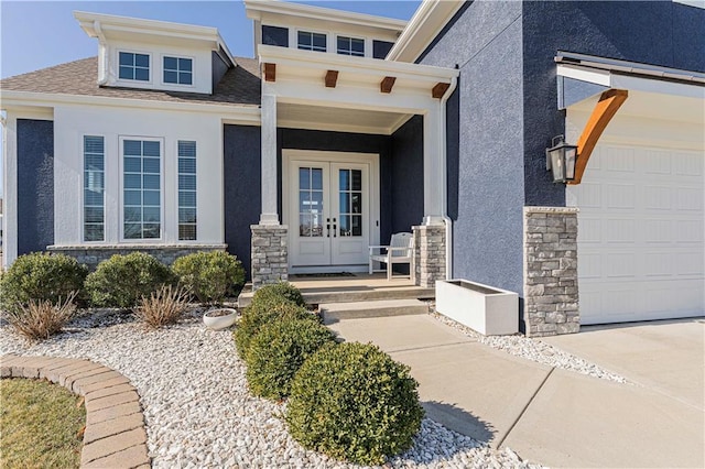 doorway to property with french doors, stone siding, driveway, and stucco siding