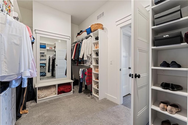 walk in closet featuring visible vents and carpet