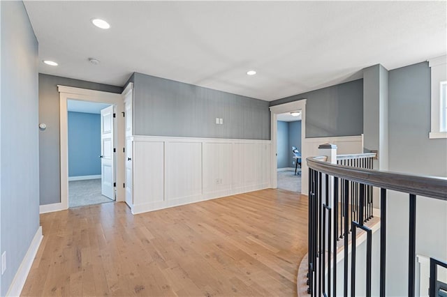 spare room featuring recessed lighting, light wood-style floors, and a wainscoted wall