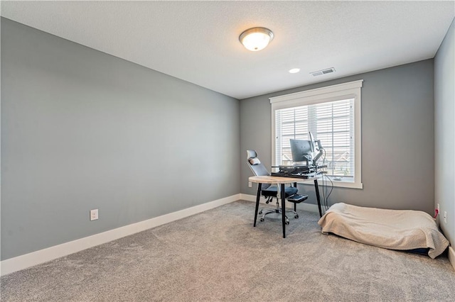 carpeted home office featuring visible vents, baseboards, and a textured ceiling