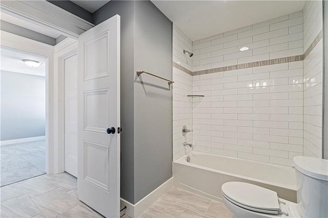 full bath with toilet, washtub / shower combination, and baseboards