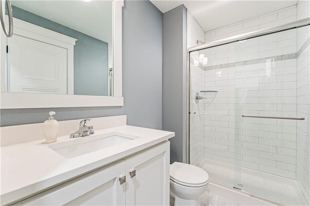 full bath with vanity, toilet, and a stall shower