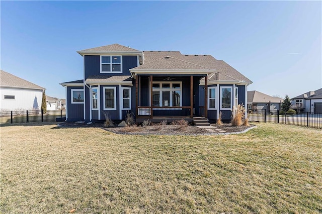 back of property featuring a yard, a fenced backyard, and a shingled roof