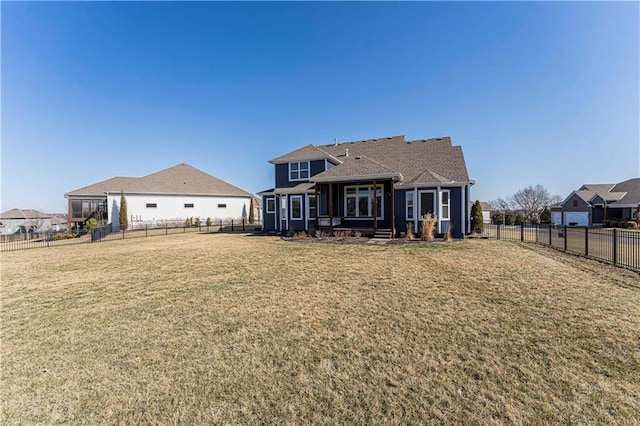 back of house featuring a lawn and a fenced backyard