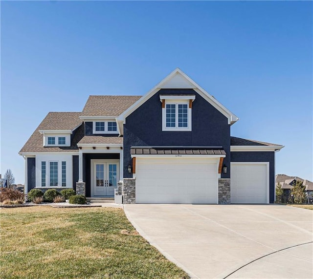 view of front of house featuring driveway, stone siding, french doors, a front yard, and a garage