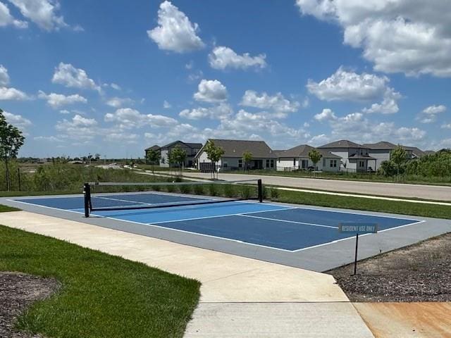 view of community featuring a tennis court, a residential view, and uncovered parking