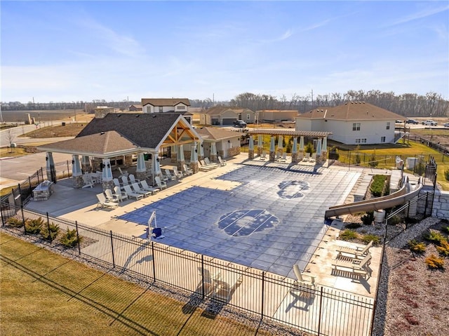 community pool featuring a pergola, fence, a patio, and a residential view