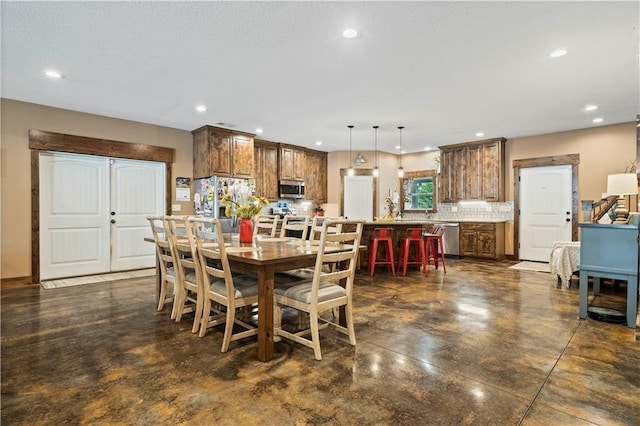 dining room featuring concrete flooring and recessed lighting