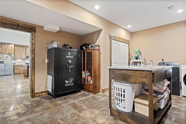 interior space featuring washer / dryer, visible vents, stainless steel refrigerator with ice dispenser, and tasteful backsplash