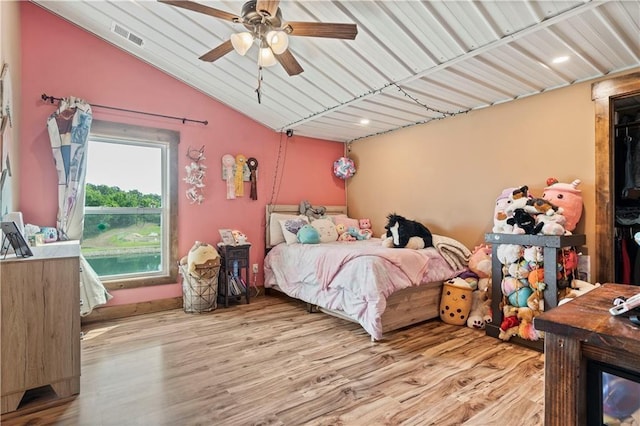 bedroom featuring lofted ceiling, ceiling fan, visible vents, and wood finished floors