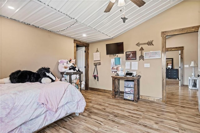 bedroom featuring light wood-type flooring, baseboards, and vaulted ceiling