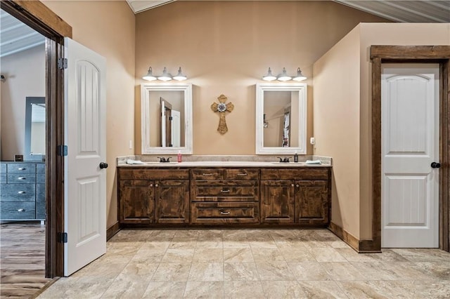 bathroom featuring a sink, baseboards, and double vanity