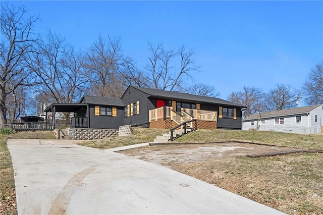 view of front of home featuring a front lawn, an attached carport, and driveway