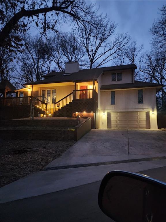 756 NW S Shore Dr, Lake Waukomis, MO 64151 - view of front facade with a garage, concrete driveway, and stairway