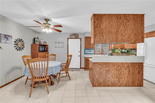 756 NW S Shore Dr, Lake Waukomis, MO 64151 - kitchen with brown cabinetry, freestanding refrigerator, light countertops, ceiling fan, and black microwave