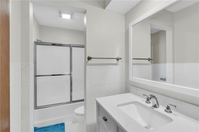 756 NW S Shore Dr, Lake Waukomis, MO 64151 - full bath with tile walls, toilet, vanity, combined bath / shower with glass door, and wainscoting