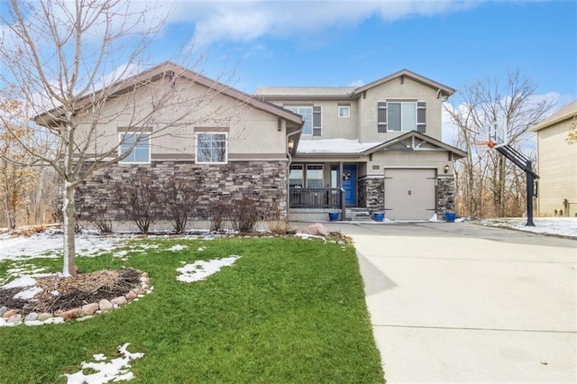 view of front of home with a garage, stone siding, a front yard, and stucco siding