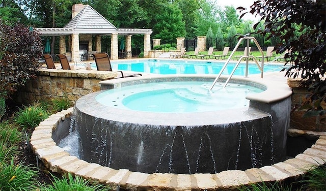 community pool with a hot tub and a patio