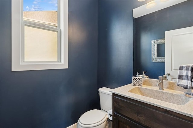 bathroom featuring vanity, toilet, and baseboards