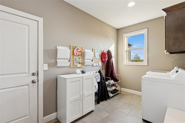 laundry area with separate washer and dryer, cabinet space, and baseboards