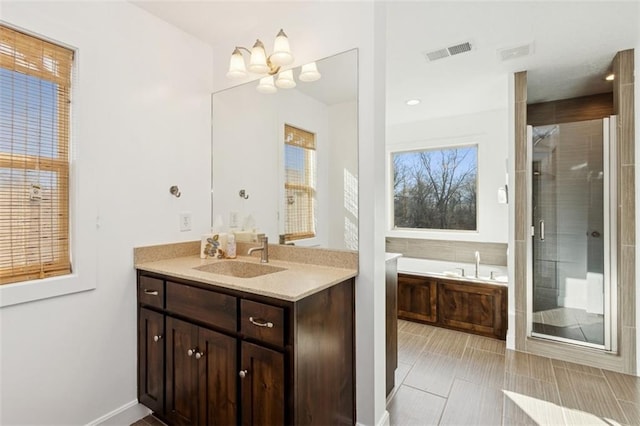 full bath with vanity, visible vents, an inviting chandelier, a stall shower, and a bath