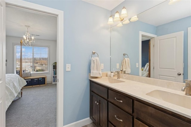 bathroom featuring double vanity, a notable chandelier, ensuite bath, and a sink