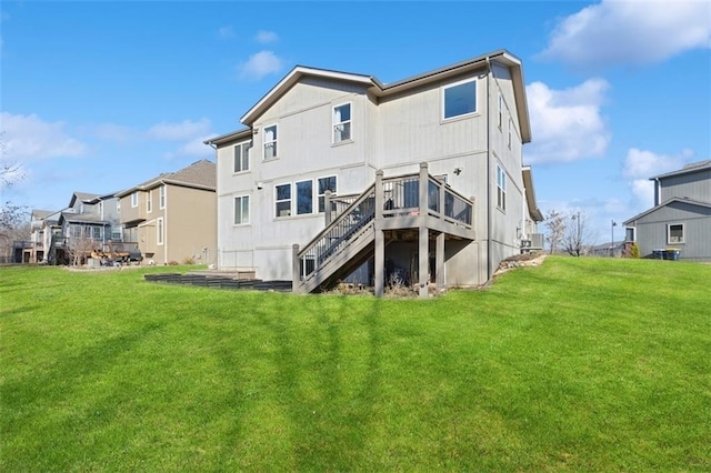 back of house with a residential view, a lawn, a deck, and stairs