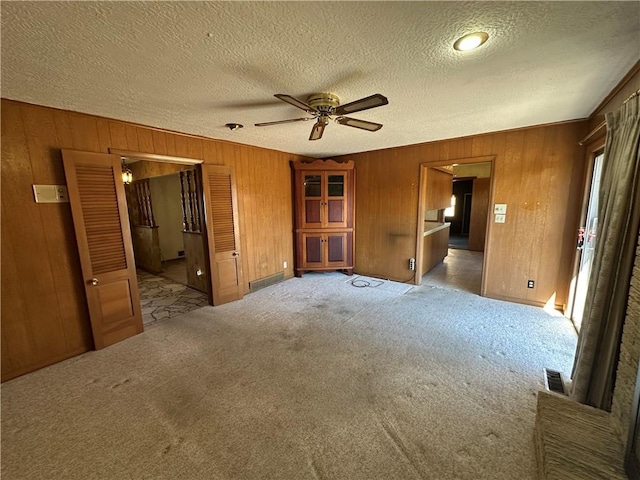 unfurnished bedroom featuring a textured ceiling, carpet, connected bathroom, and visible vents