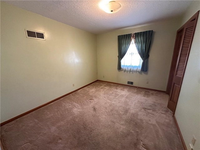 unfurnished bedroom with carpet, visible vents, and baseboards