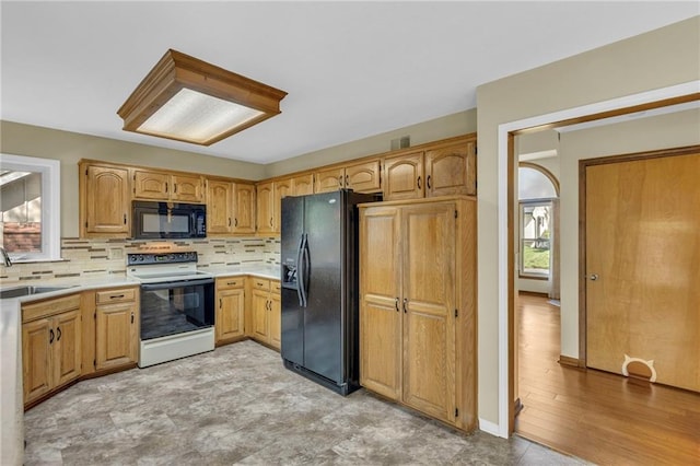 kitchen with backsplash, visible vents, a sink, light countertops, and black appliances