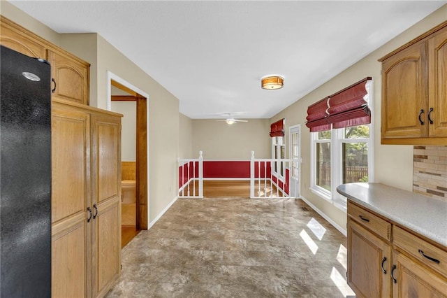 kitchen featuring baseboards, light countertops, and a ceiling fan