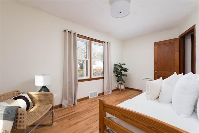 bedroom with visible vents, light wood-style flooring, and baseboards