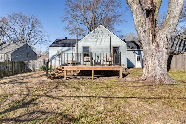 back of house featuring a yard, a wooden deck, and a fenced backyard