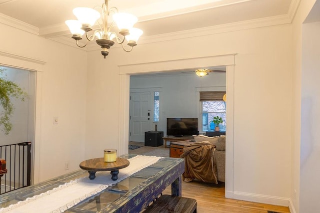 dining room with a chandelier, light wood-type flooring, baseboards, and crown molding