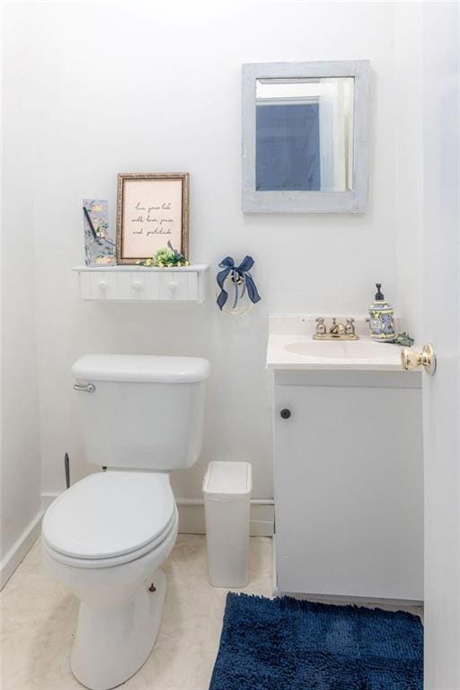 bathroom with tile patterned flooring, baseboards, vanity, and toilet