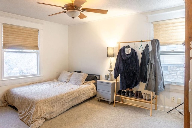 bedroom with a textured ceiling, carpet floors, ceiling fan, and crown molding