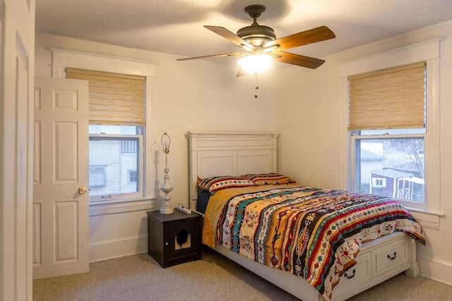 bedroom featuring light carpet, baseboards, and a ceiling fan