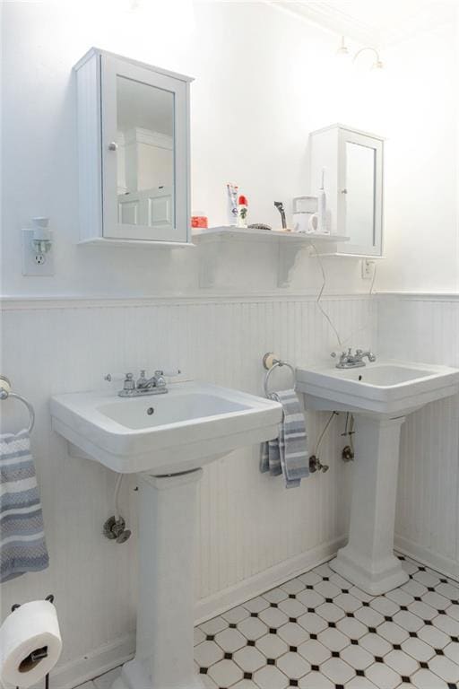 bathroom featuring tile patterned floors, a sink, and wainscoting