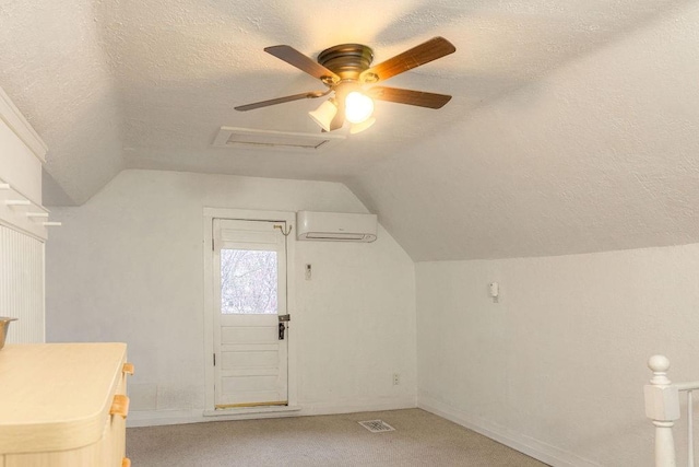 bonus room with lofted ceiling, light colored carpet, visible vents, a textured ceiling, and a wall mounted air conditioner