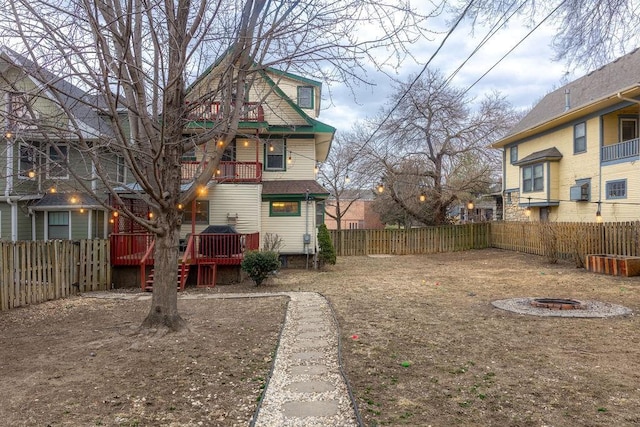 view of yard featuring a fenced backyard, a fire pit, and a wooden deck